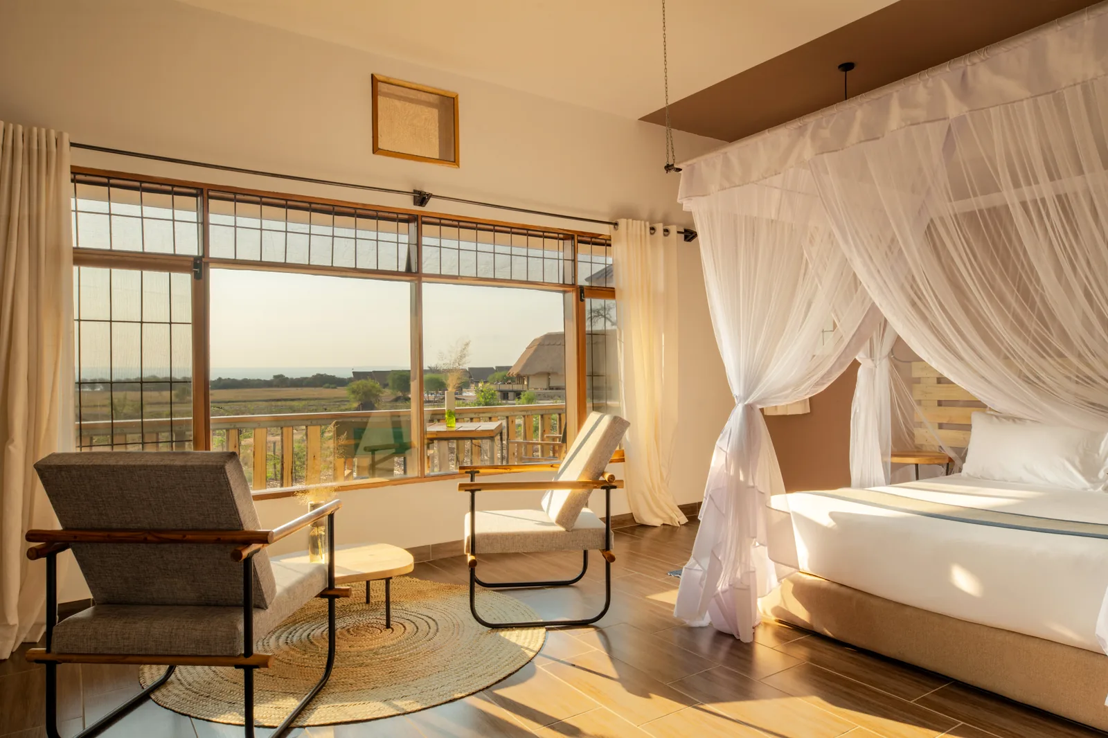 Bedroom with a netted double bed and a wide window over the plains