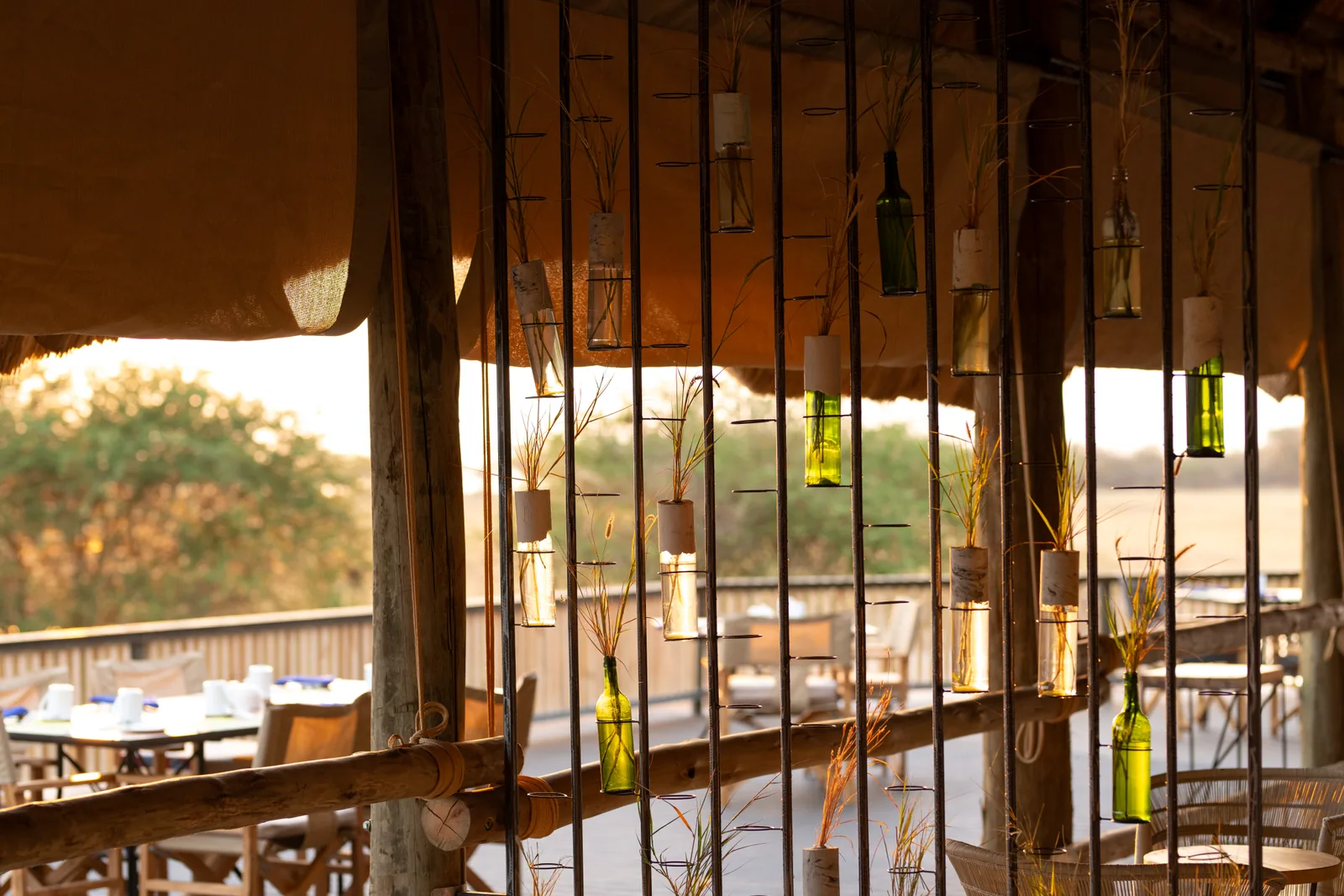 Dining terrace seen through a screen of hanging glass lanterns