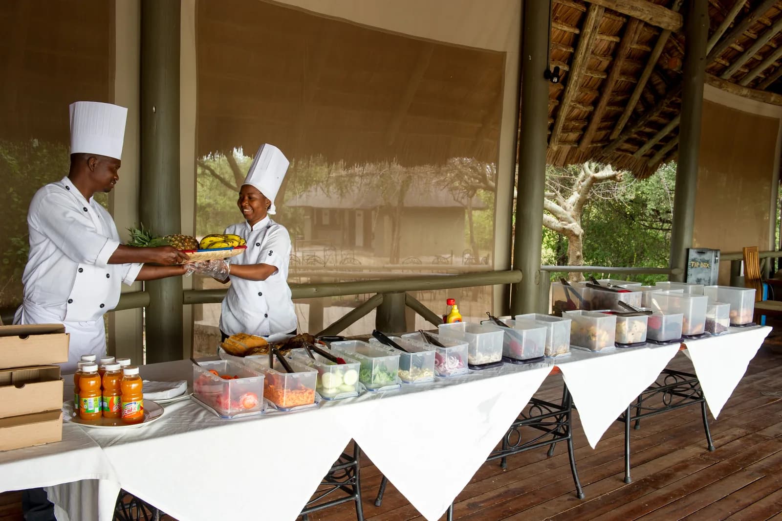 Two chefs at a breakfast buffet on the open-sided dining deck