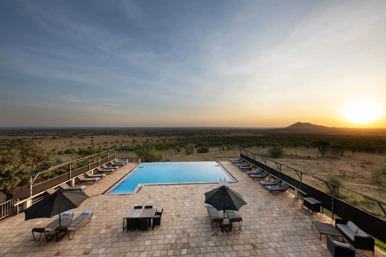Swimming pool on a hilltop terrace above the plains at sunset at Kubu Kubu Tented Lodge