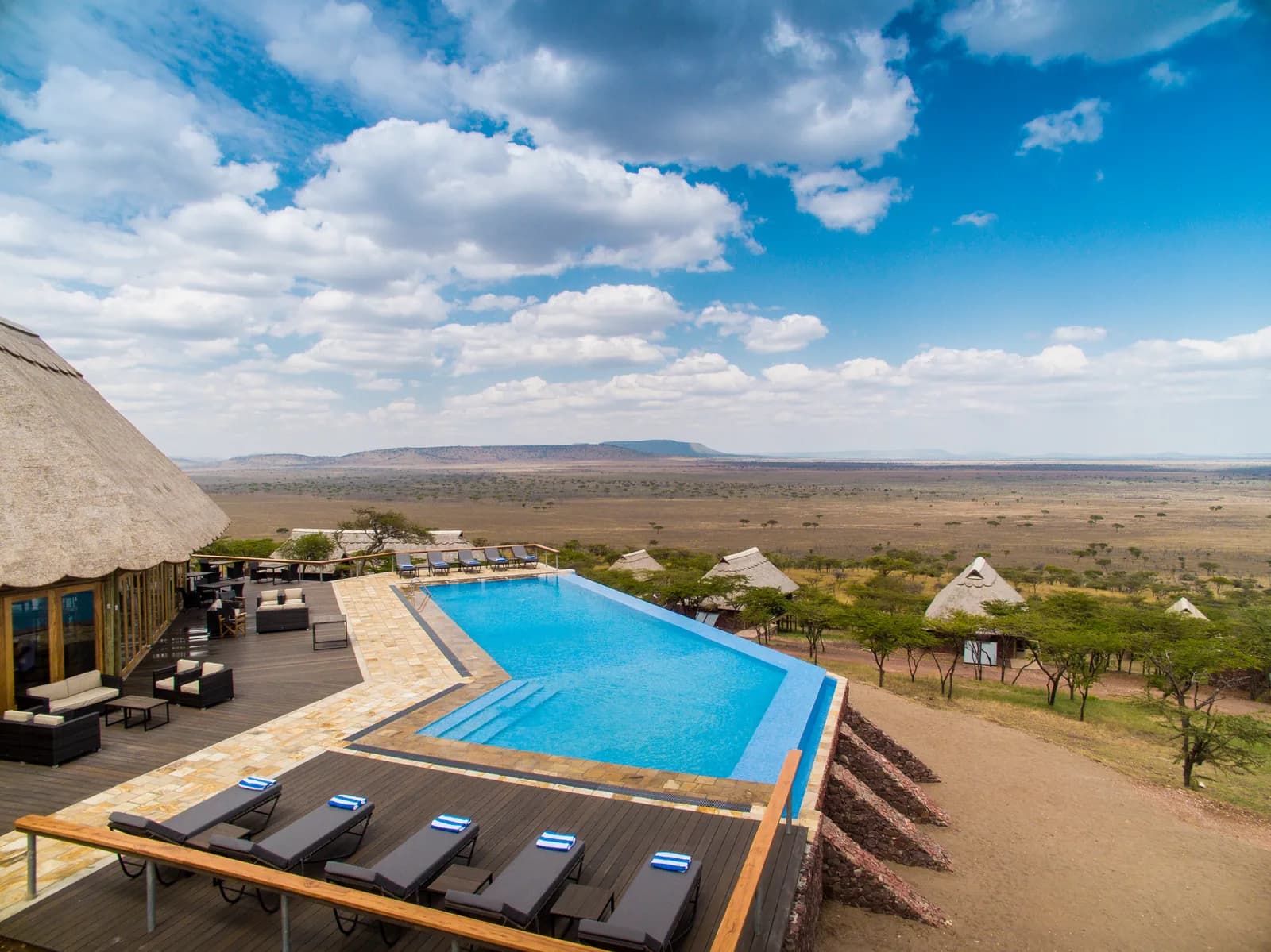 Infinity pool and sun loungers on a terrace high above the plains at Lahia Tented Lodge