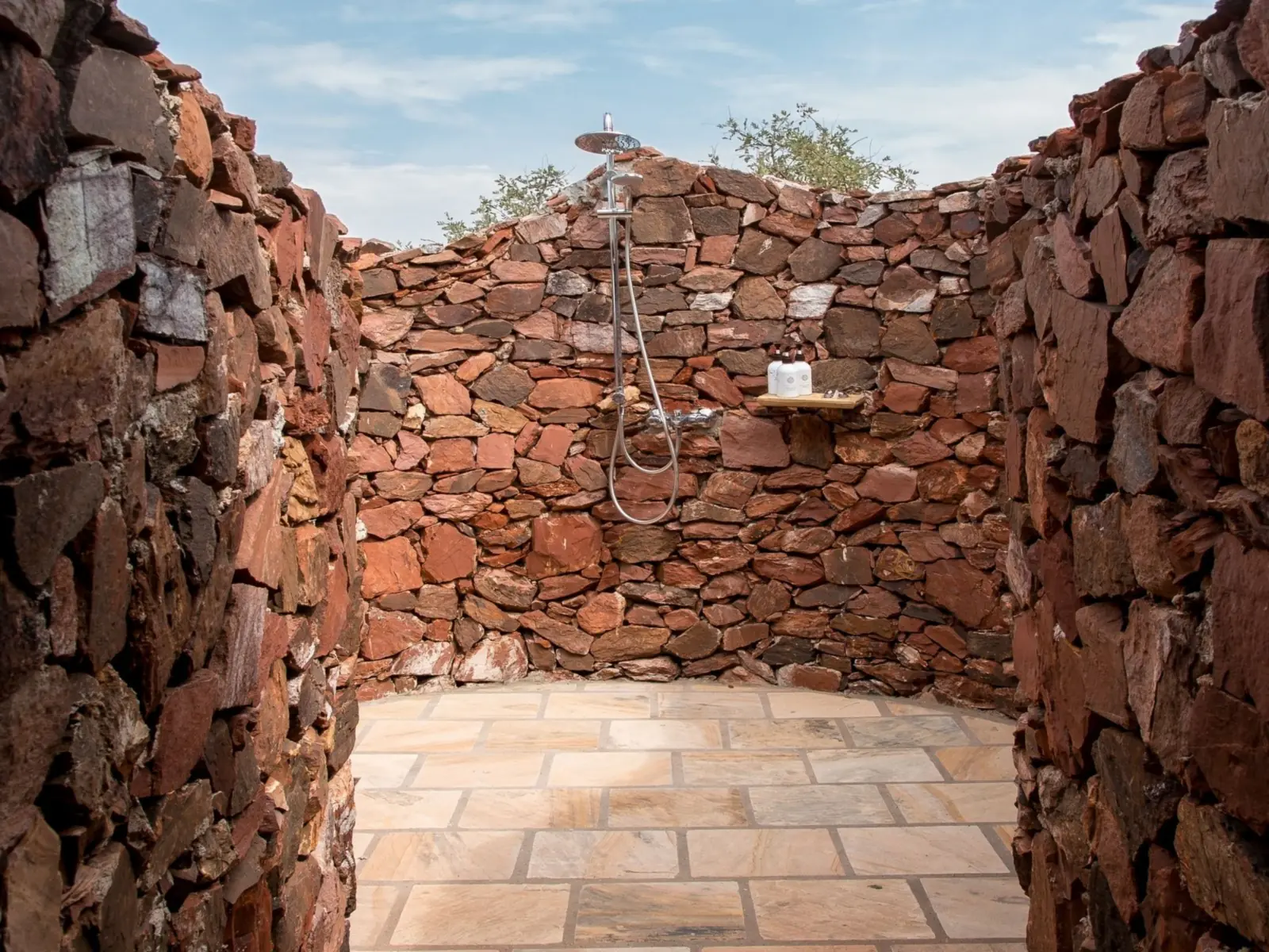 Open-air shower between stone walls