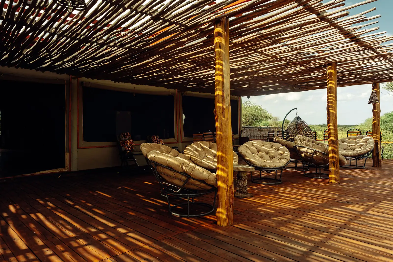 Shaded veranda with cushioned chairs under a reed roof