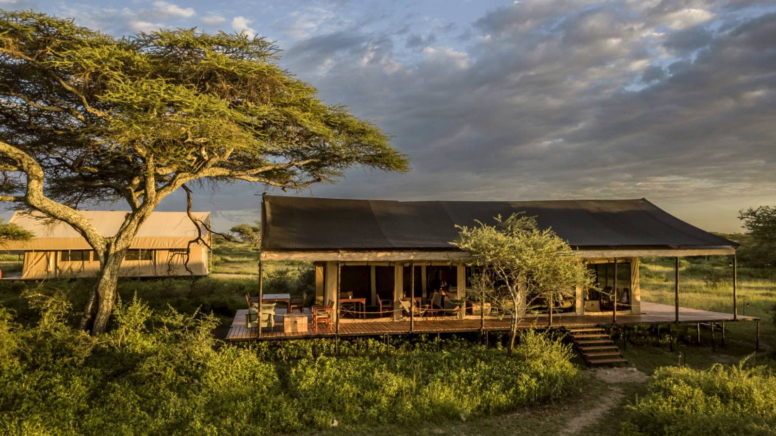 Private deck of a tented camp looking out over the Tanzanian wilderness at dusk