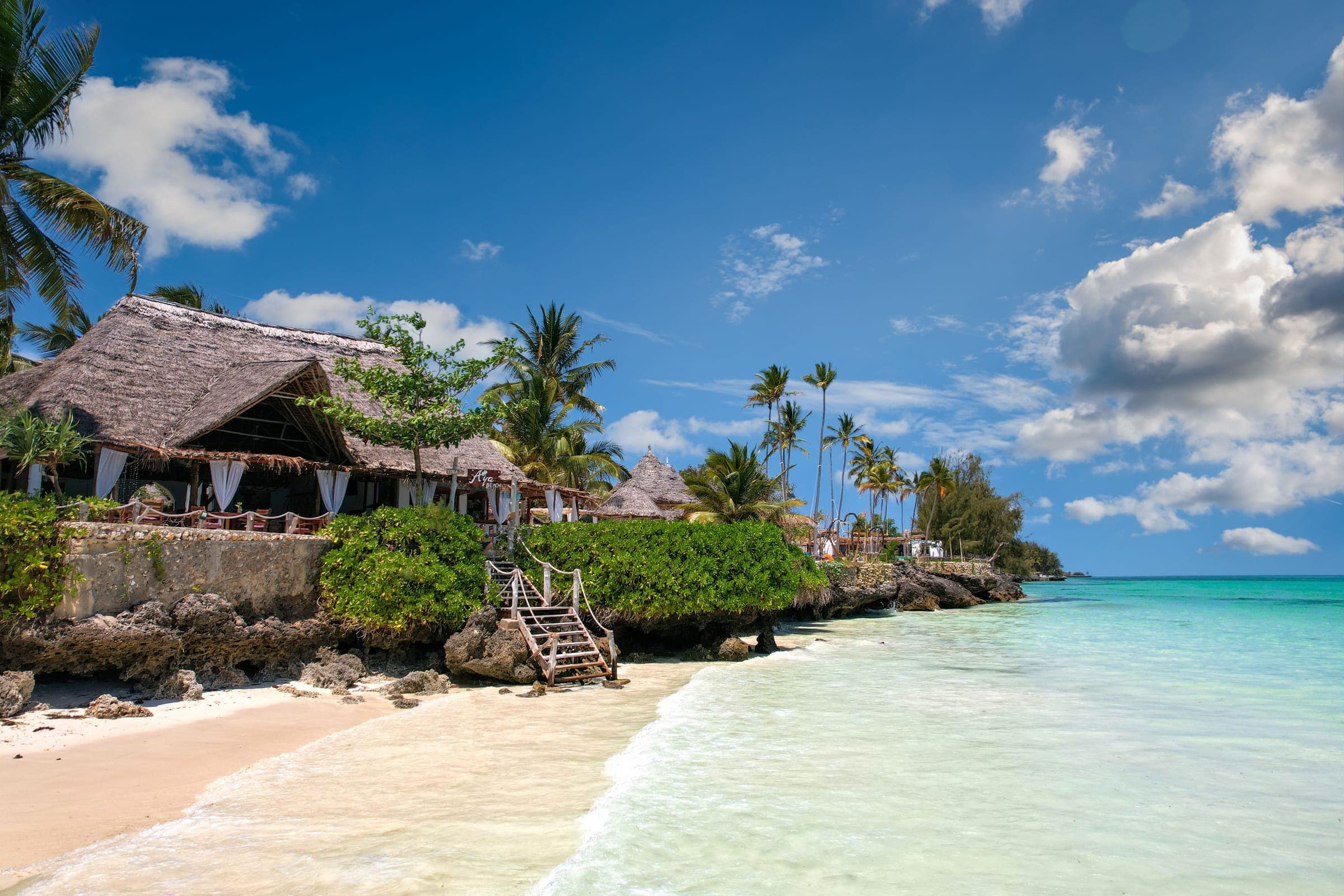 Thatched beach restaurant above turquoise water on Zanzibar's coast