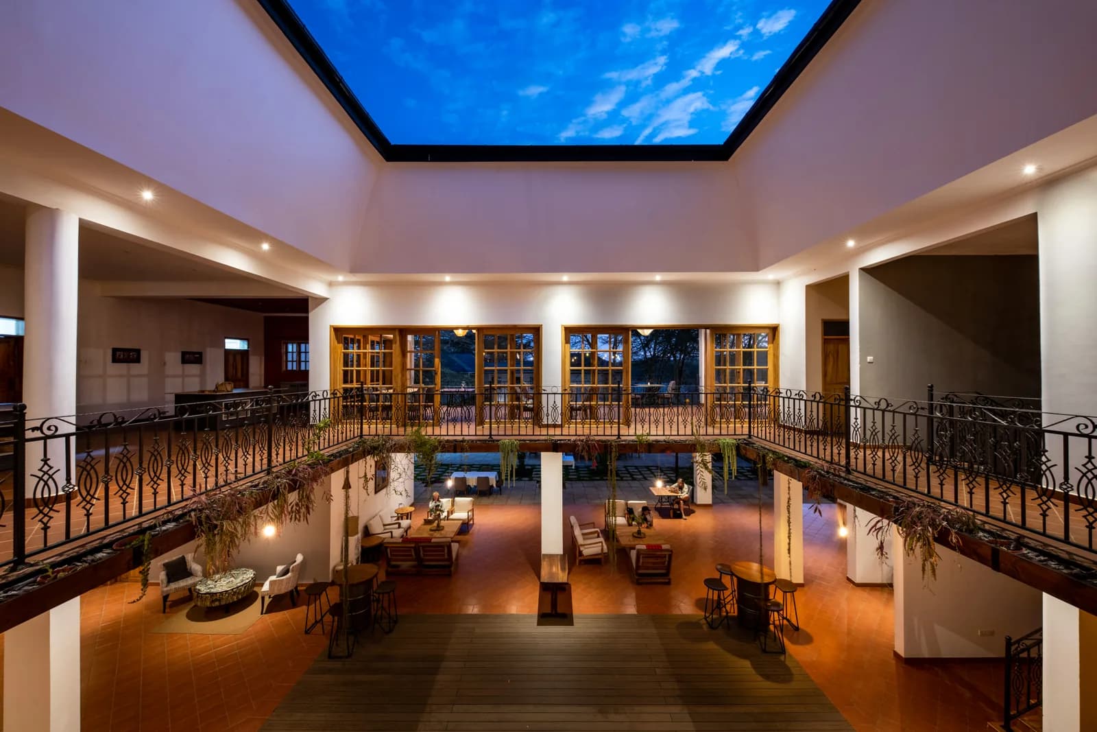 Covered central courtyard with a lounge below and a wrought-iron gallery above