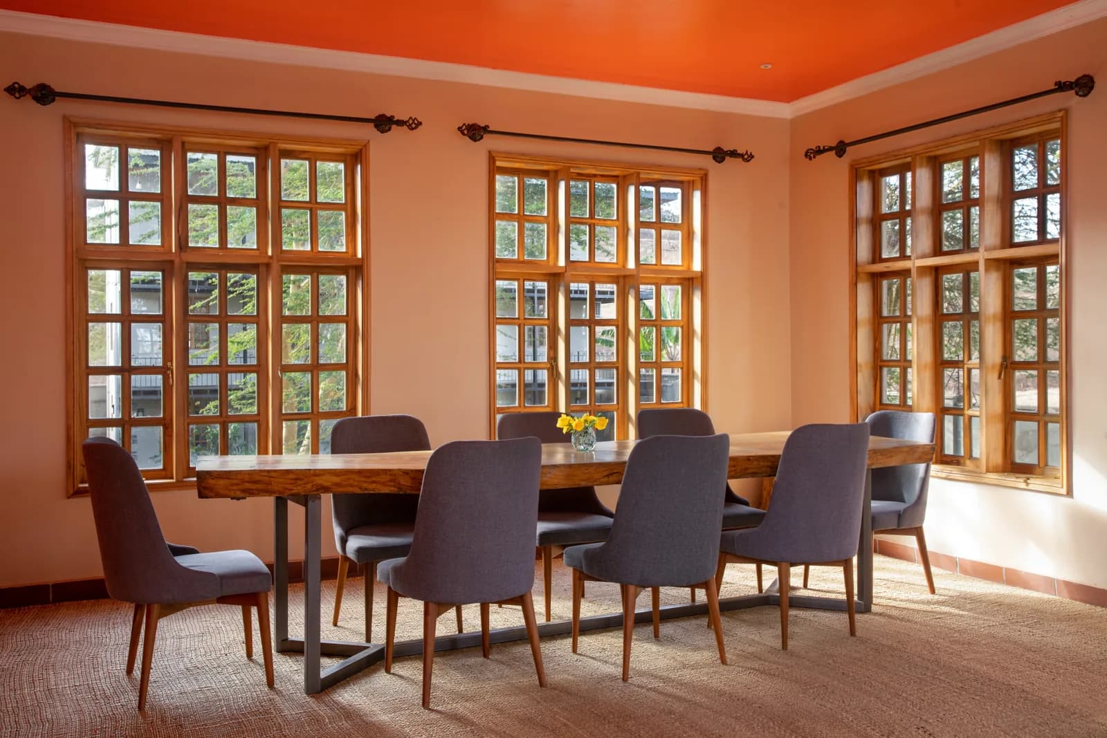Dining room with a long wooden table and tall windows