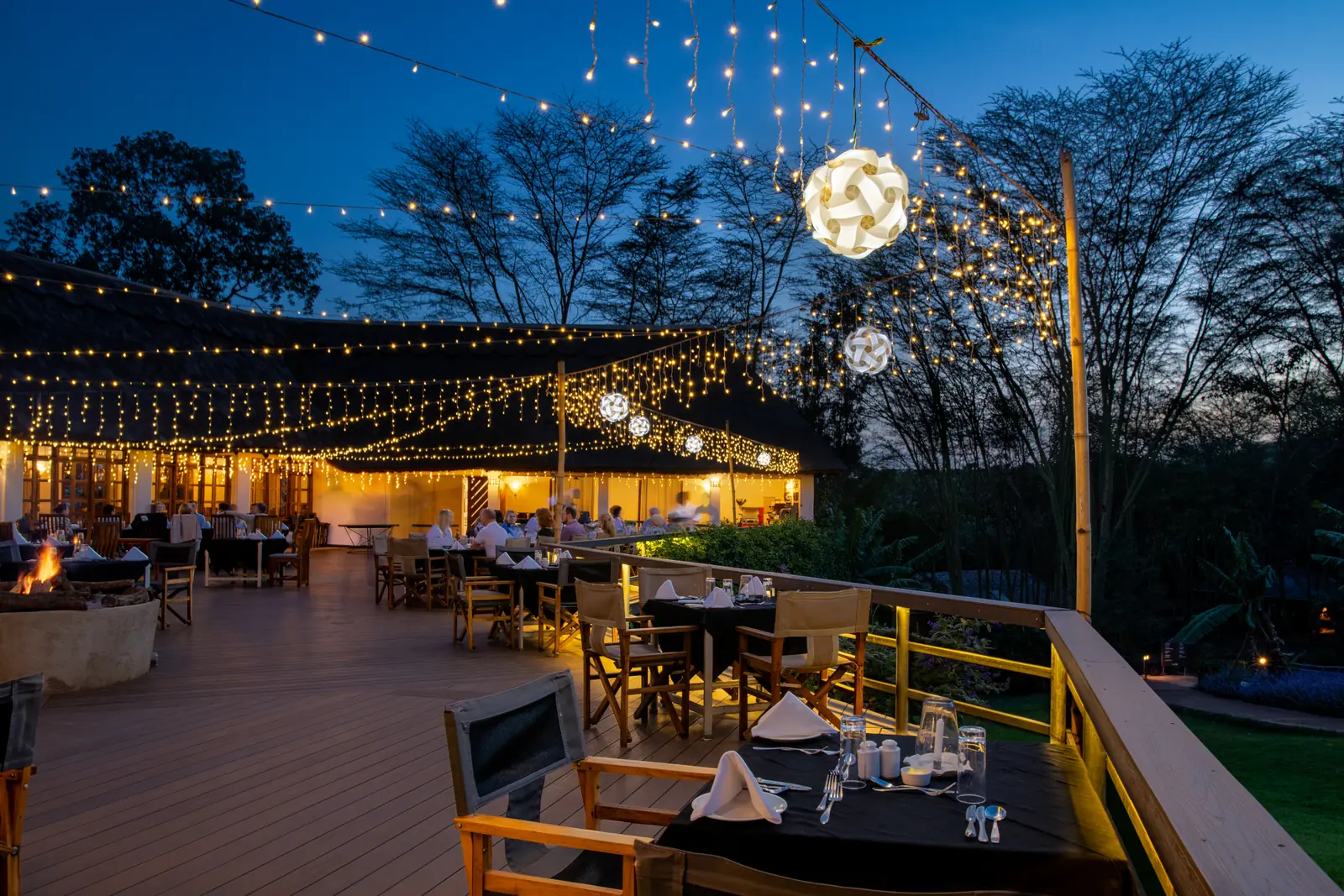 Dining deck under strings of fairy lights in the evening