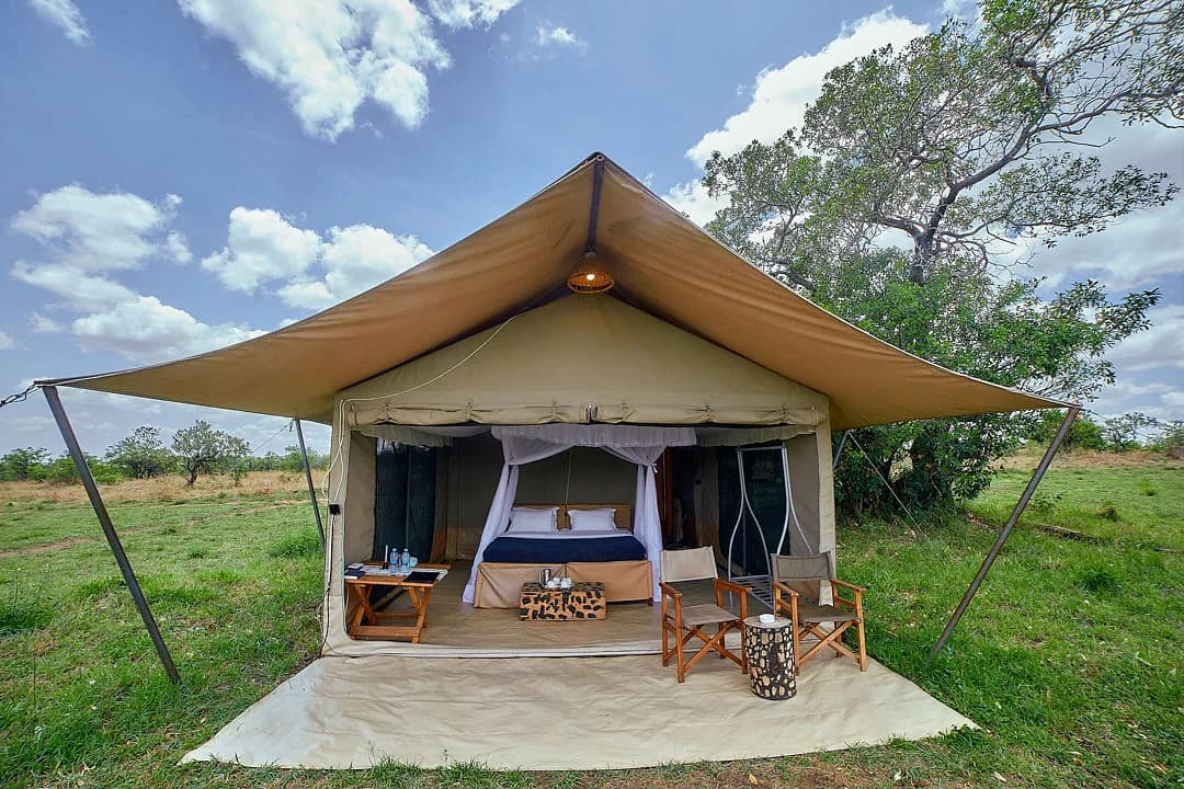A guest tent with its front open and chairs outside, under a big sky