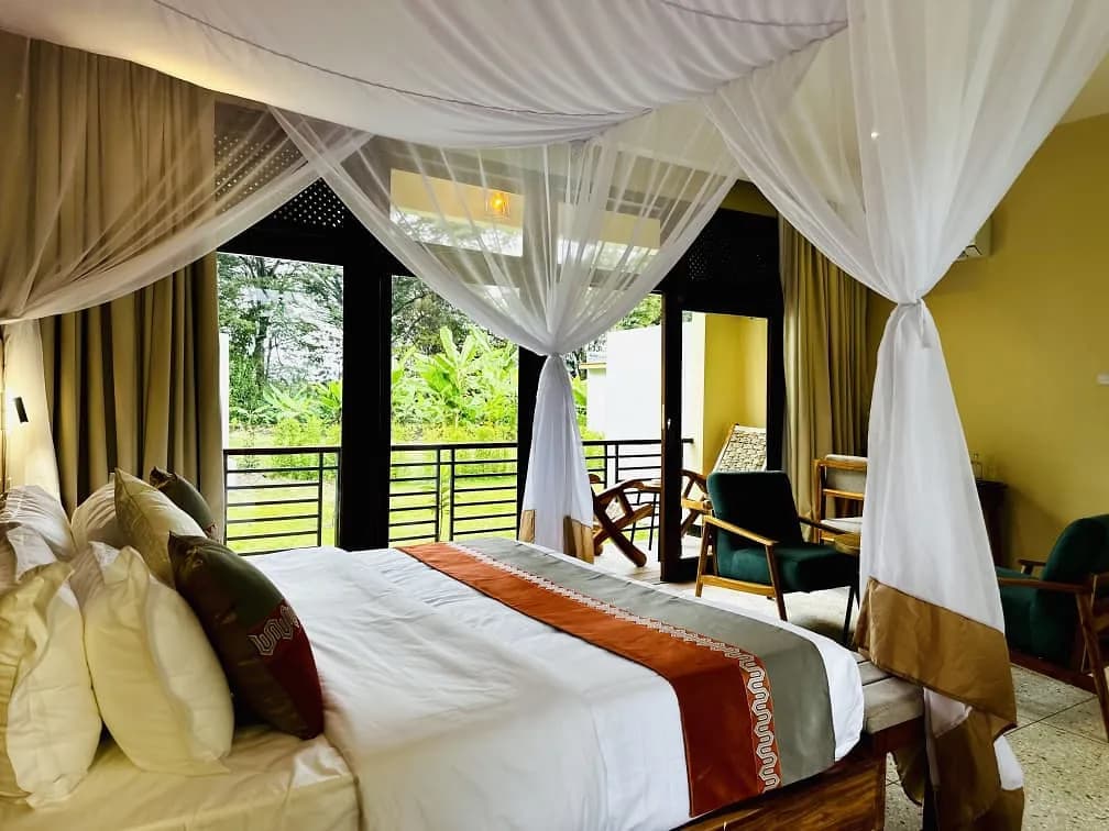 Netted double bed with glass doors onto a balcony over the garden