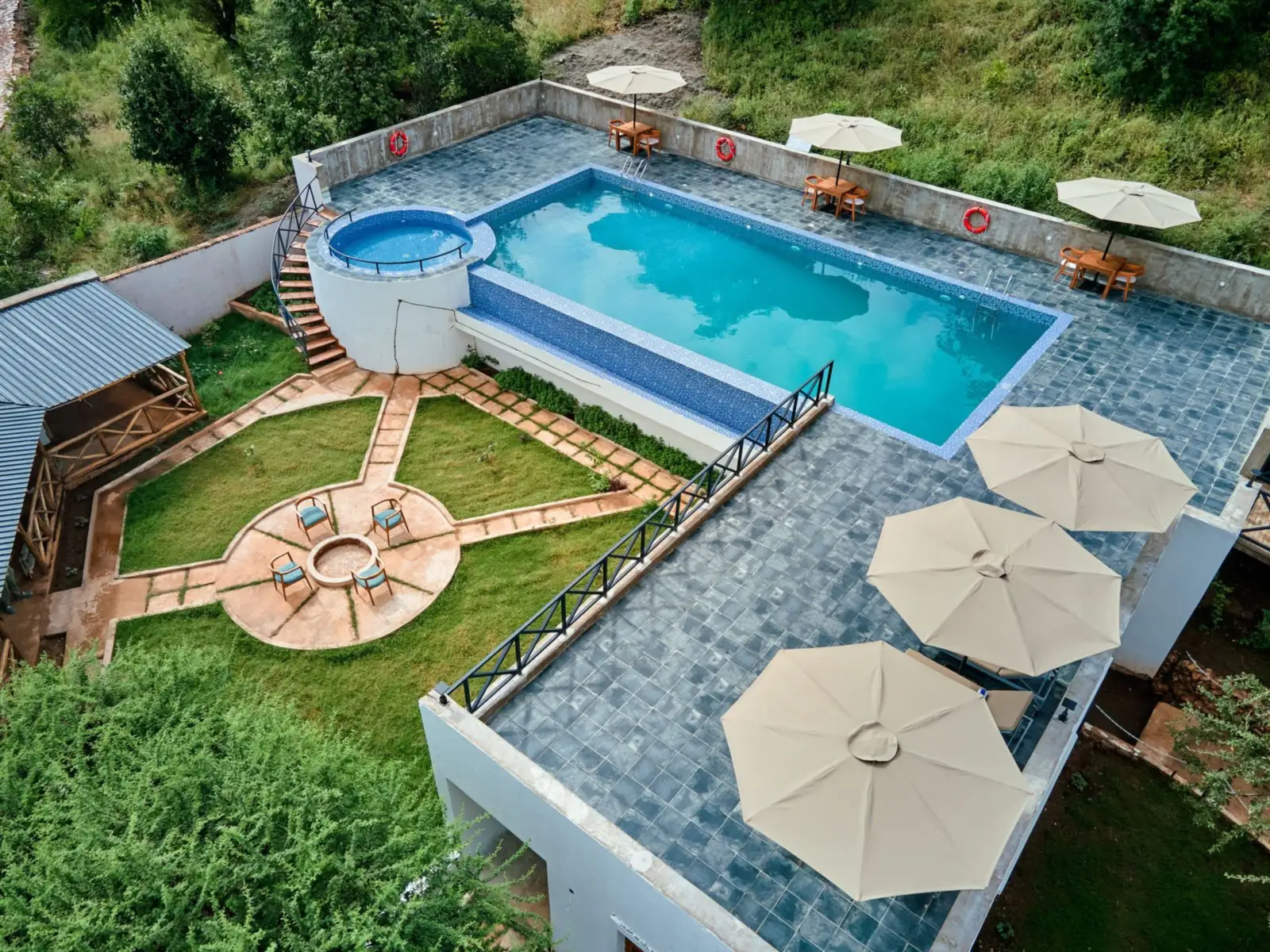 Aerial view of the pool, plunge pool, firepit and parasols on the hillside