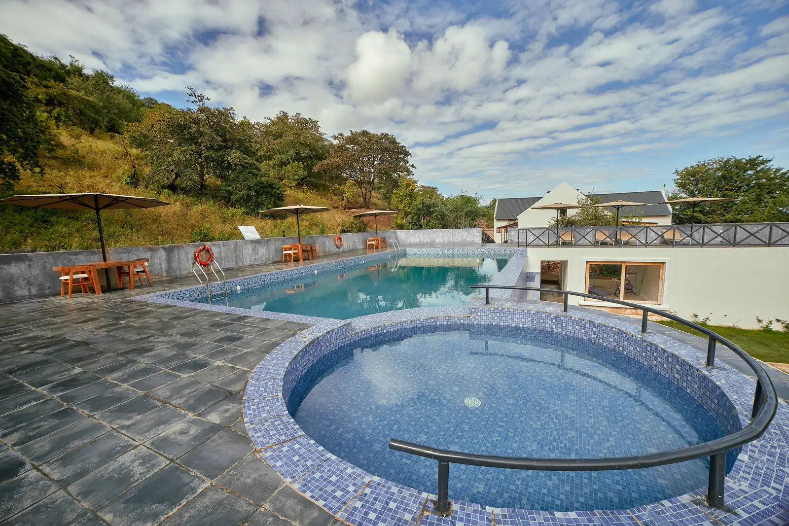 Round plunge pool with the main pool and the hillside behind